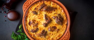 tave kosi e un piatto nazionale albanese di agnello al forno e riso con yogurt in una padella sul tavolo vista superiore orizzontale dall alto nome turco elbasan tava 693630 10691.jpg