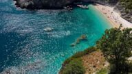 Acque turchesi con barche e spiaggia.